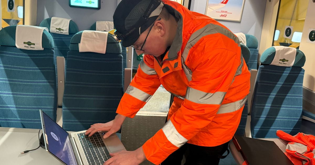 Engineer using a laptop inside a Southern Railway train