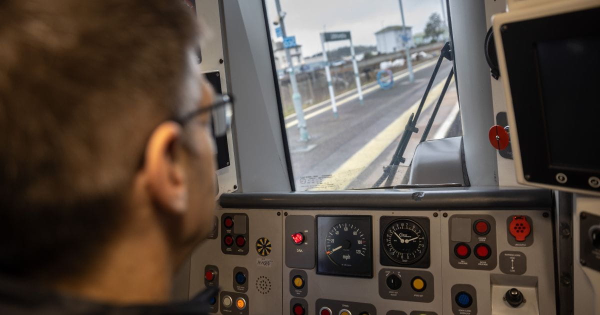 Train driver looking out front of train cab