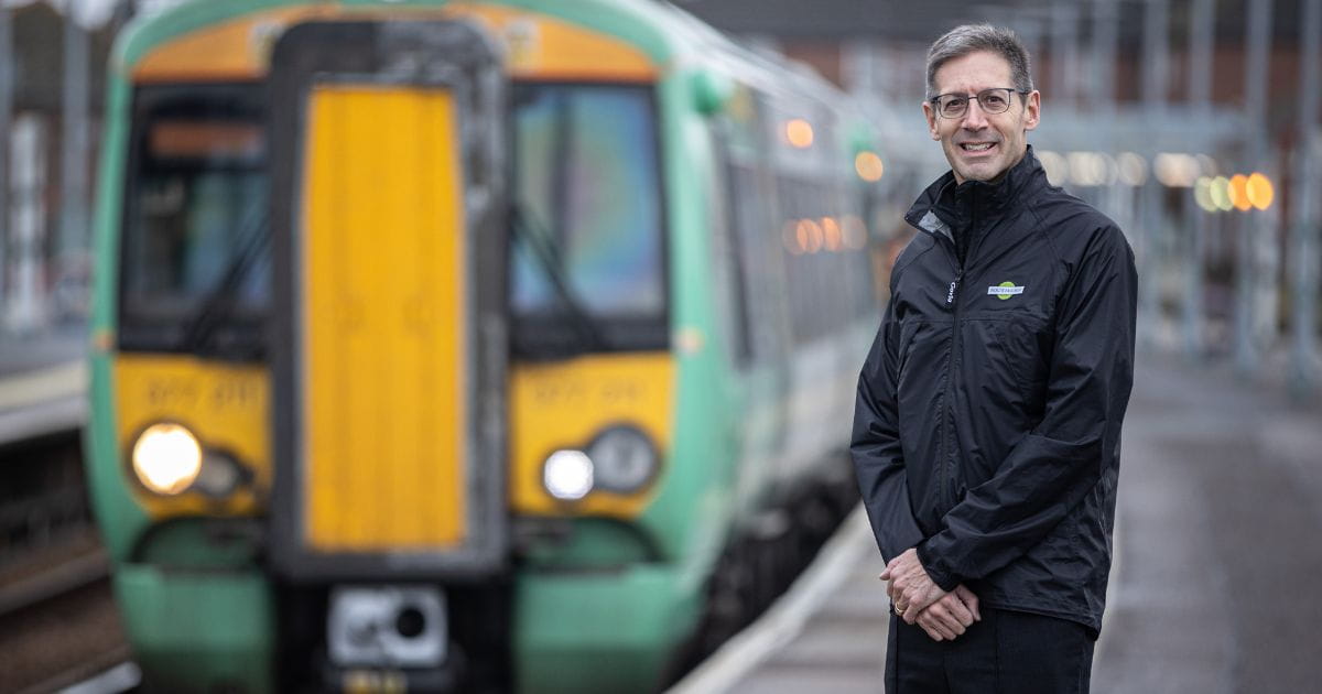 Train driver Paul Freegard standing on a platform with Southern Railway train in the background