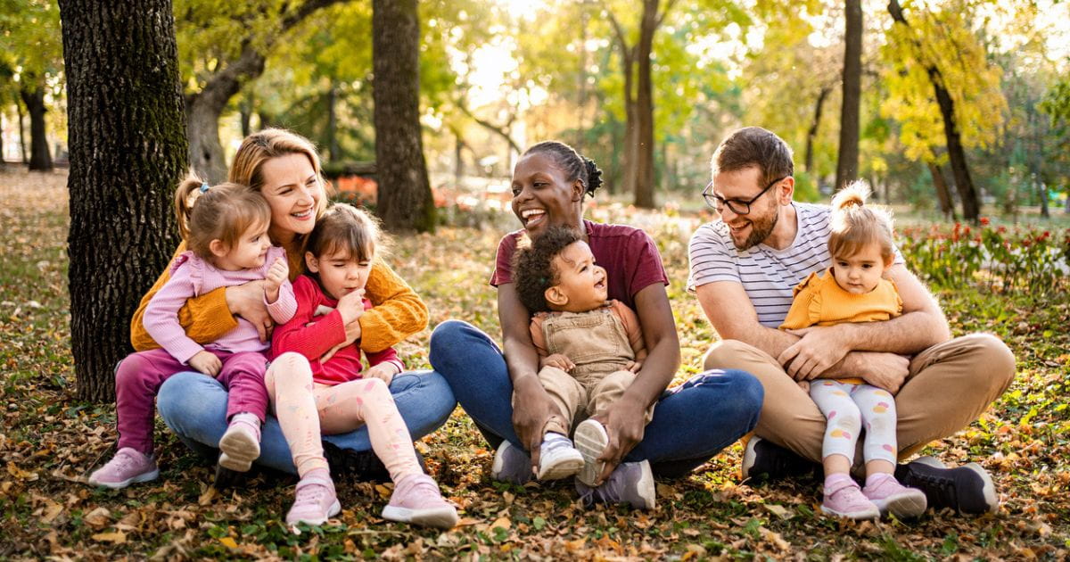 group of parents and children having fun outdoors in the woods