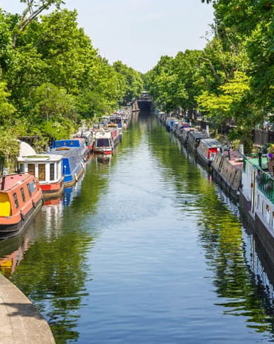 A river with canal boats moored on the side