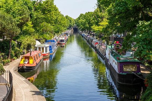 Boats moored on the side of a canal of Little Venice Regents Canal