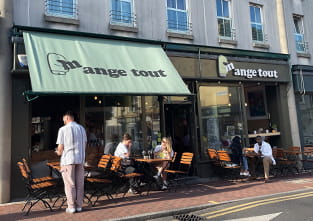 View of a cafe with people sitting at tables outside