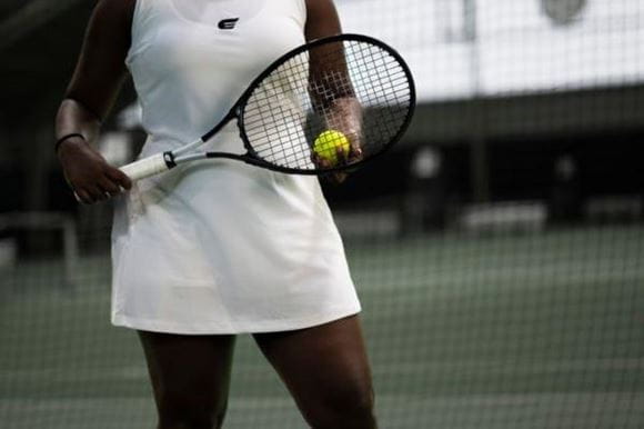 Woman playing tennis wearing whites