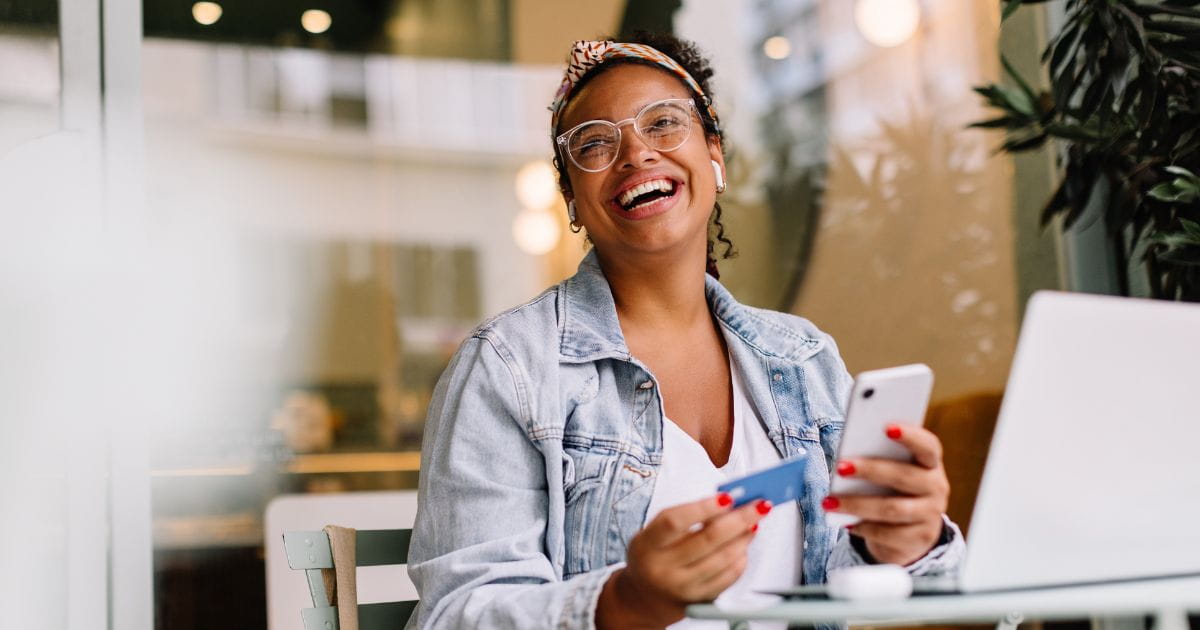 woman using a credit card with smartphone and laptop