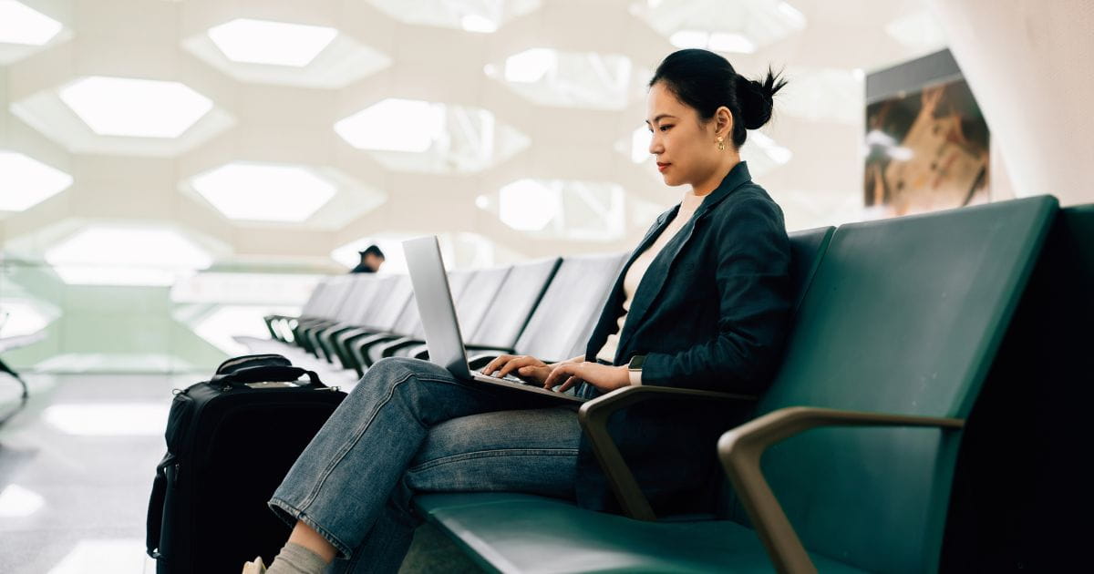 Woman in an airport lounge working on a laptop