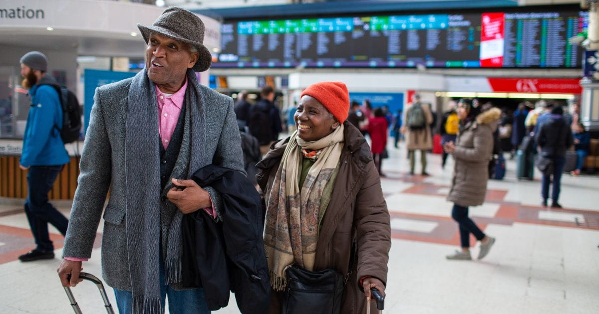 Southern railway passengers smiling carrying luggage in railway station