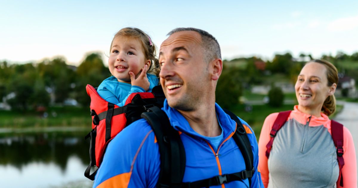 Family with young child going on a walk around a lake