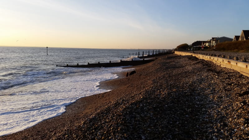 a sandy beach next to a body of water