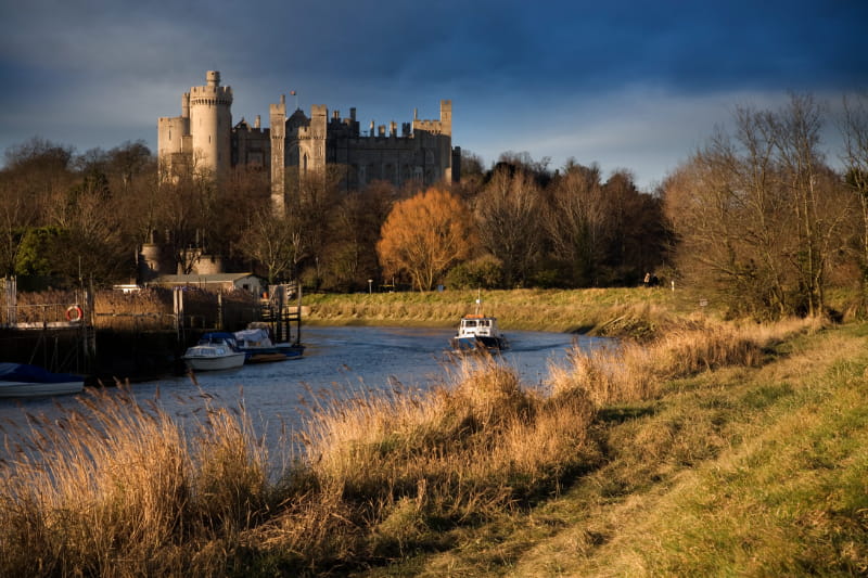 a castle on top of a river next to a body of water
