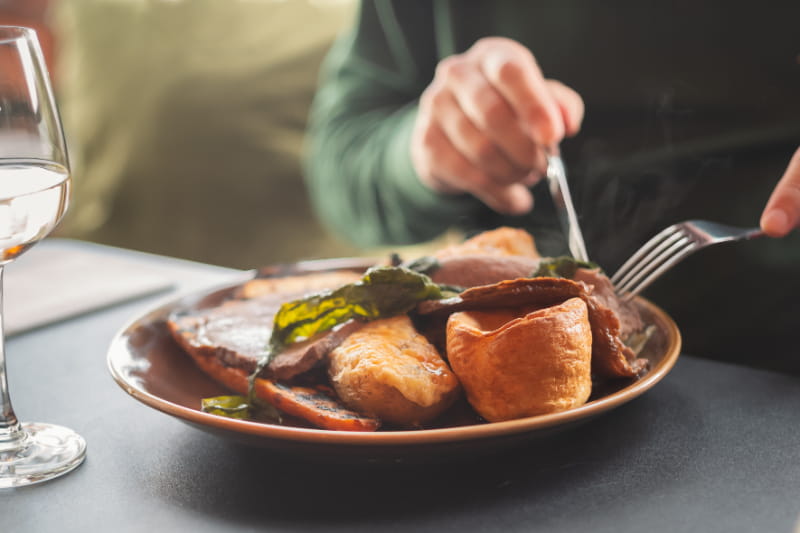 a person sitting at a table with a plate of food