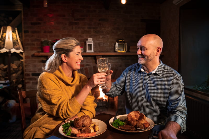 a person sitting at a table with a plate of food
