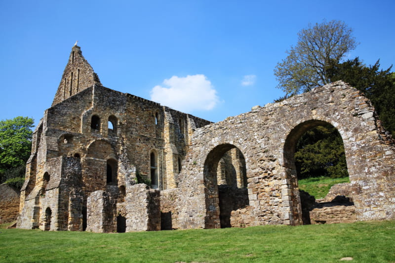 a large stone building with grass in front of a brick wall