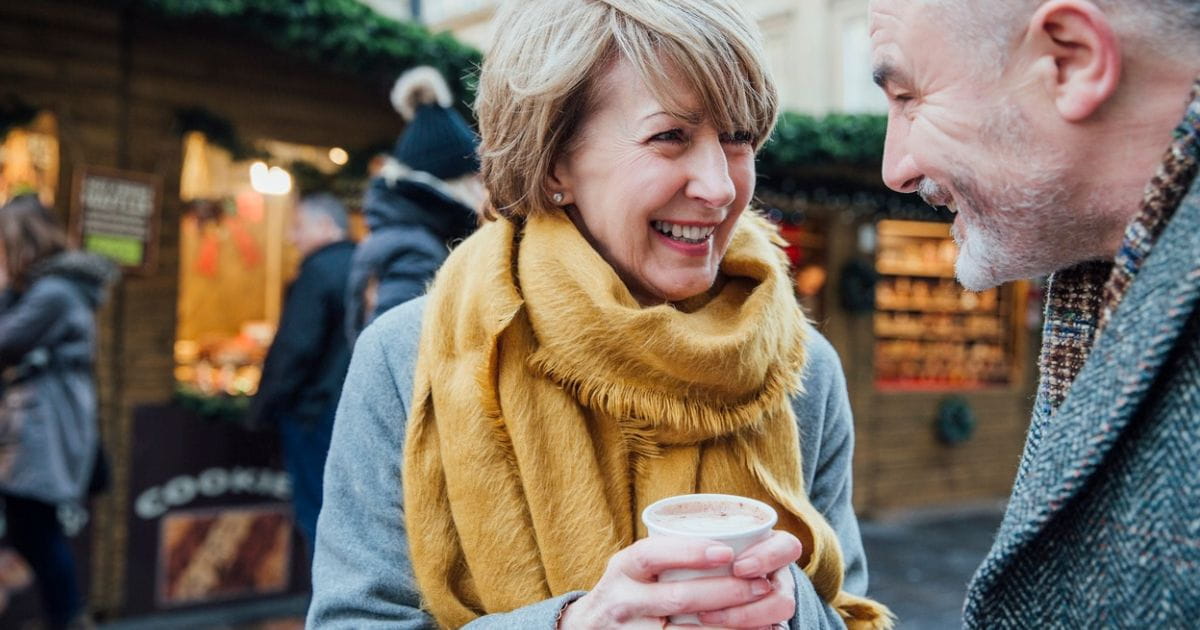 Older couple at a Christmas market with drinks