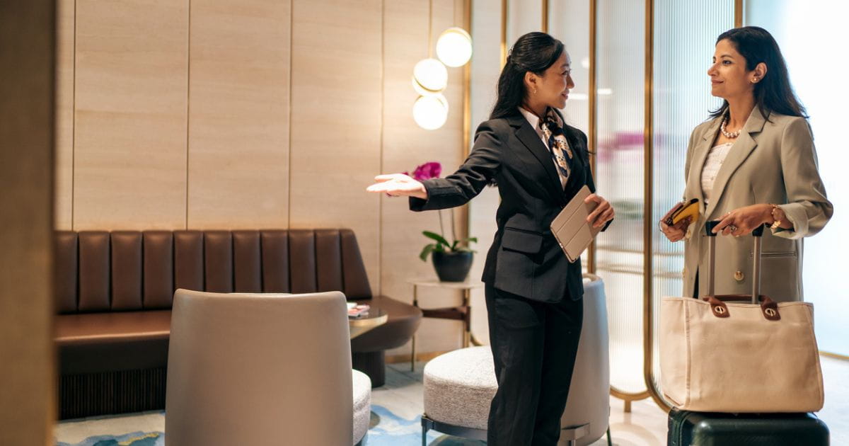 Woman in uniform welcoming a passenger to an airport lounge