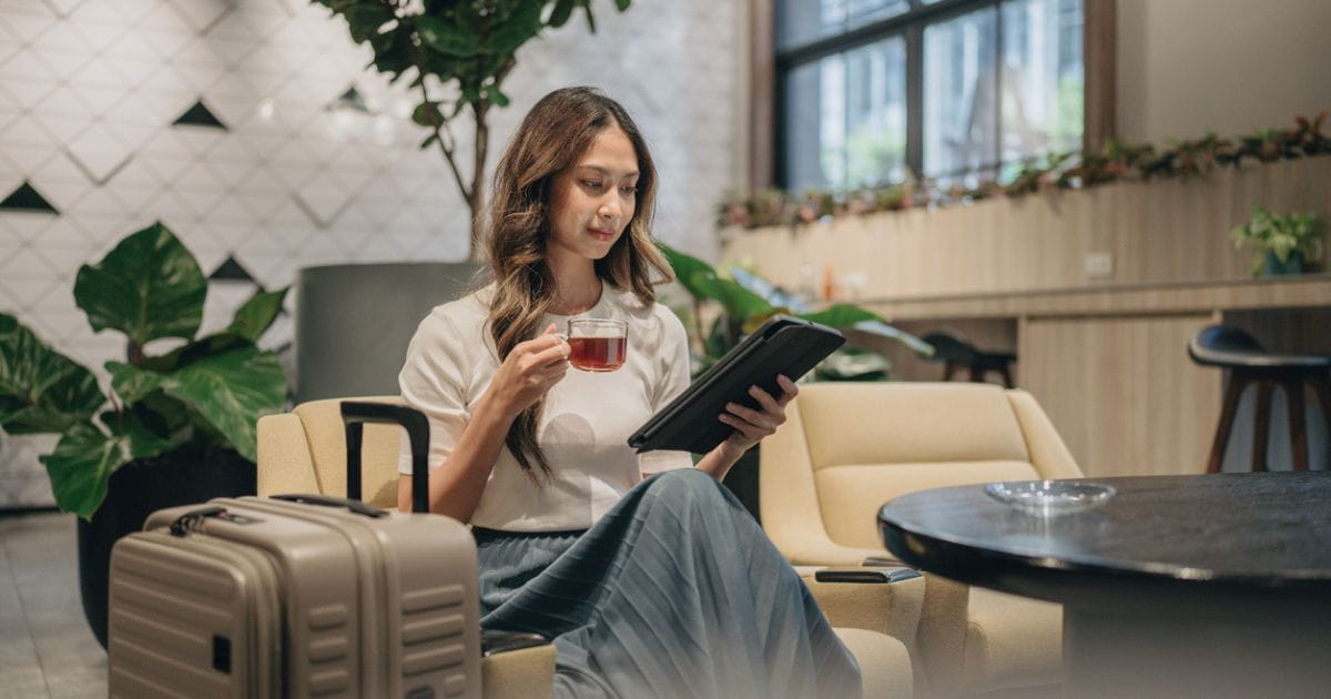 Young woman enjoying a drink in an airport lounge