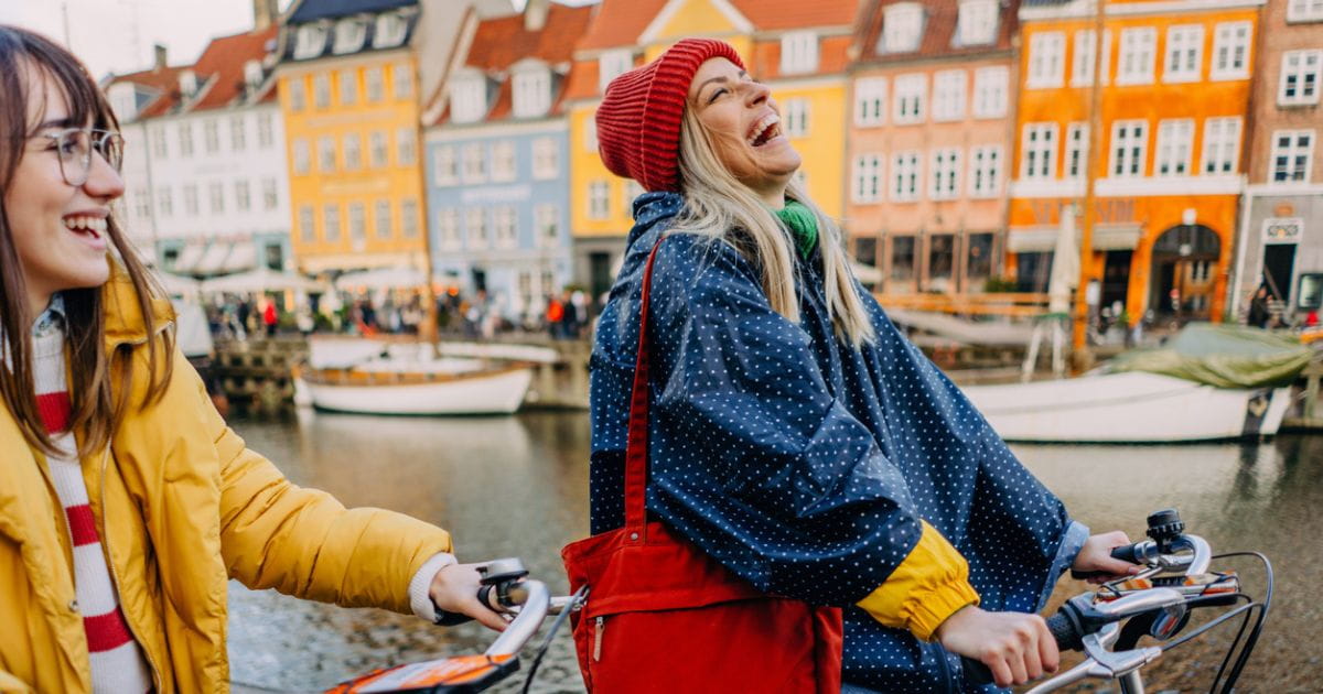 Women cycling laughing in Copenhagen on holiday