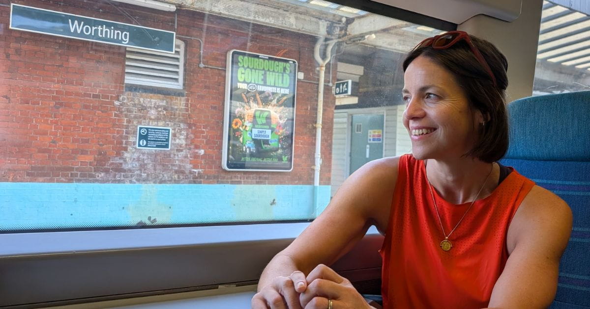 A woman smiling on a Southern railway train in Worthing