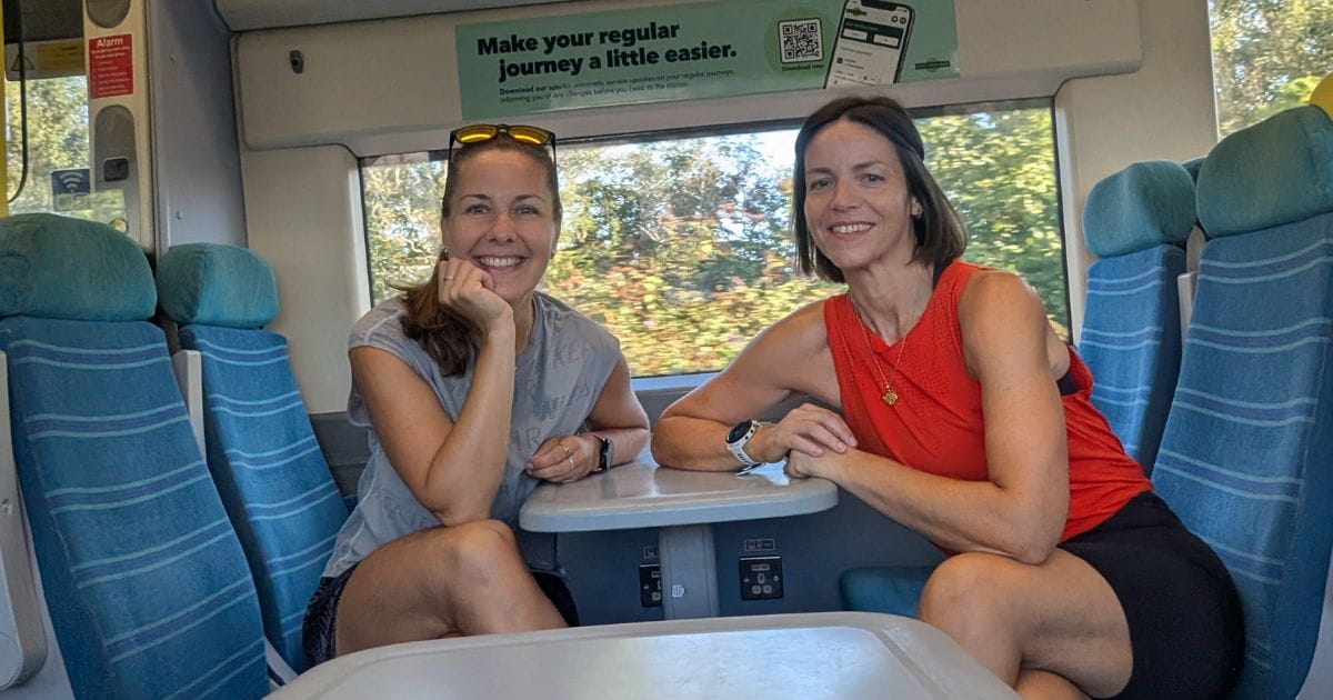 Two runners smiling on a Southern Railway train