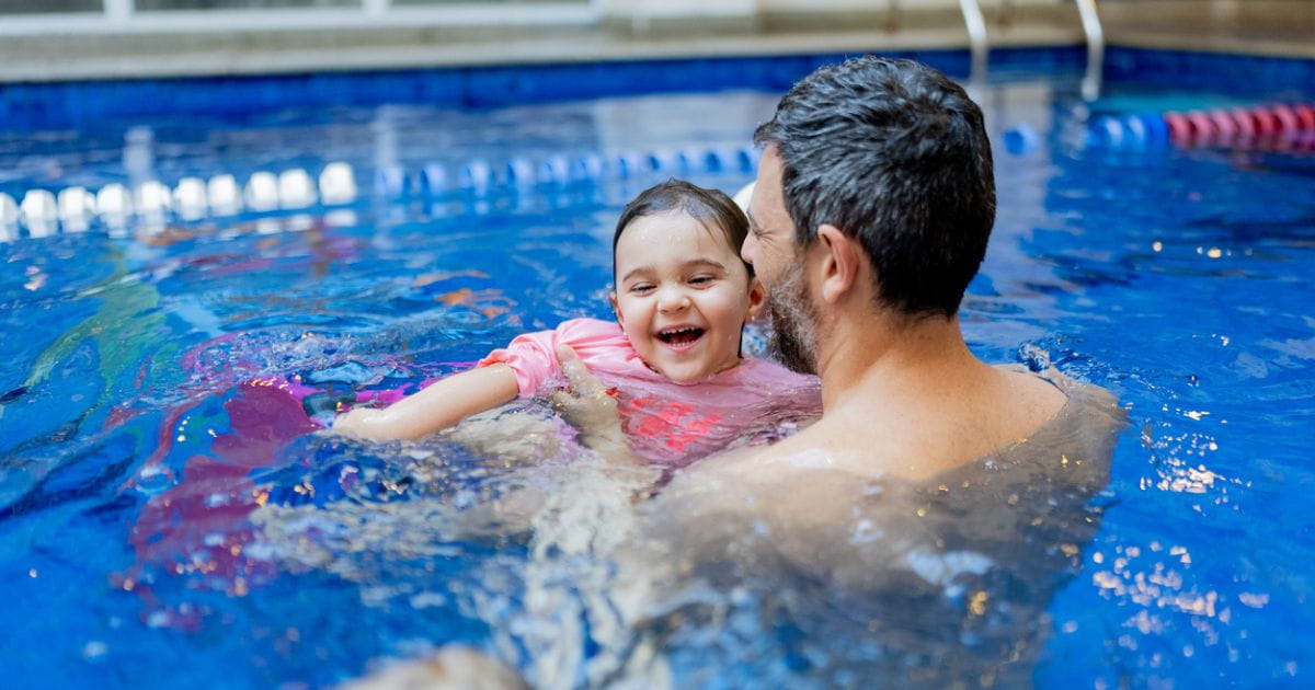 Family swimming in leisure centre pool