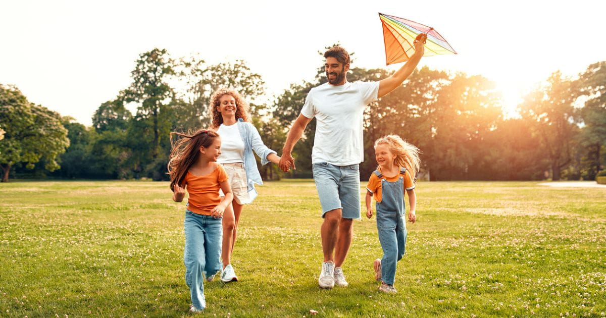 Family with children having fun running in a park
