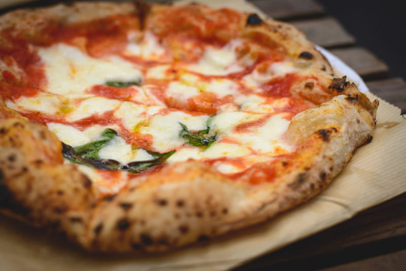 a pizza sitting on top of a wooden table