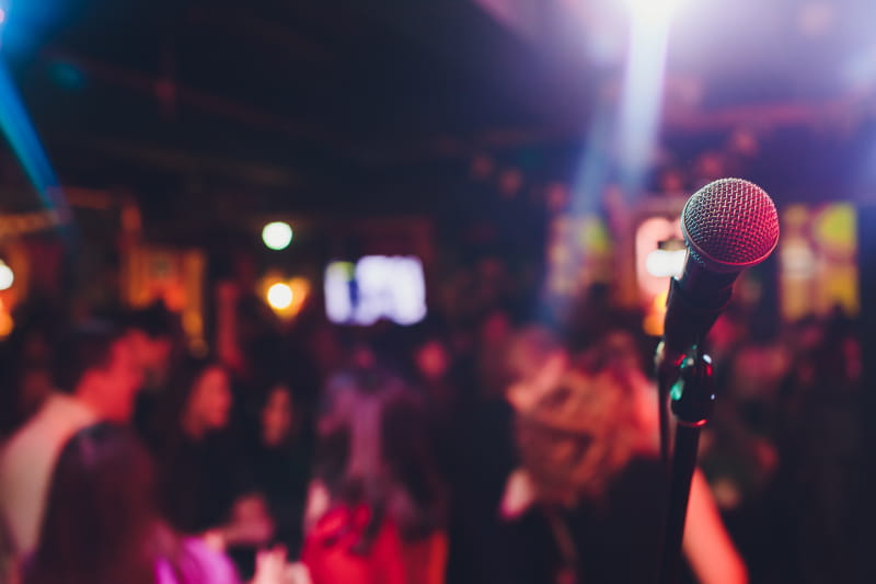 a person holding a microphone in front of a crowd